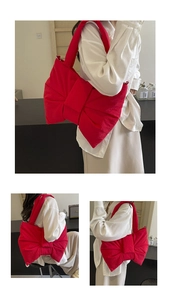 Detail of red oversized nylon bow shoulder bag worn by model in a stylish indoor setting