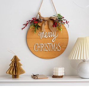 Close-up of wooden Merry Christmas hanging sign with pine cones and a burlap bow decoration
