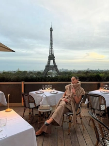 Détail d'un gilet élégant en fausse fourrure beige porté sur une terrasse à Paris
