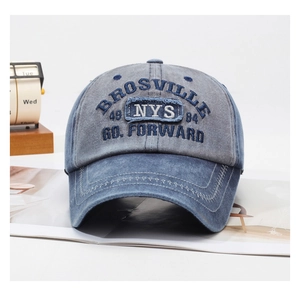 Detail of washed denim baseball cap with vintage embroidery and two-tone stitching