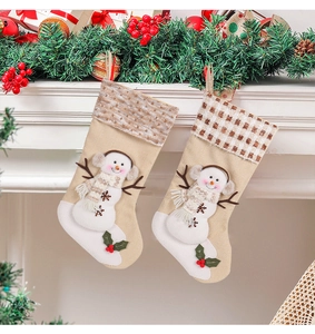 Detail of Christmas stockings with snowman decor hanging on a festive fireplace mantel