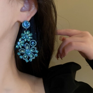 Vintage blue rhinestone flower dangle earrings shown on model in a luxury style