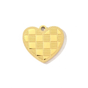 Détail macro d'un pendentif cœur doré avec motifs gaufrés en damier et vagues
