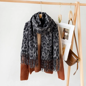 Elegant leopard print scarf with fringe tassels draped on a sweater for winter warmth