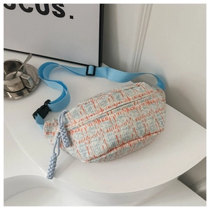 Detail of blue and orange striped woven crossbody bag with adjustable blue strap