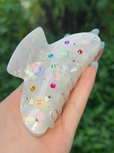 Dettaglio della molletta per capelli in acrilico con farfalle colorate e strass