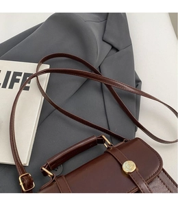 Detail of adjustable long shoulder strap on vintage dark brown crossbody bag