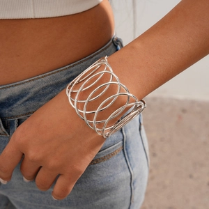 Detailed close-up of a silver open cuff bracelet with geometric circular hollow patterns