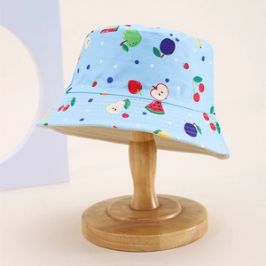 Close-up of children's blue sun hat with vibrant fruit patterns on cotton fabric