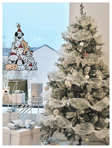 Window sticker showing cartoon dogs stacked as a Christmas tree in a cozy room