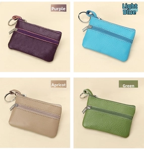 Close-up of pebble grain leather coin purses with dual zippers and metal keyrings