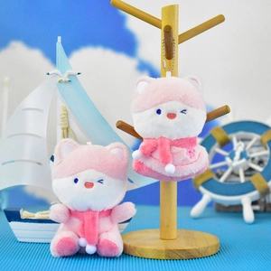 Detailed view of two cute pink fox plush pendants on a nautical-themed display