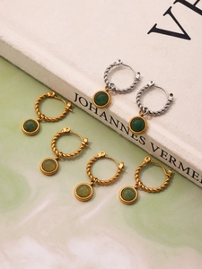 Detailed view of twist-textured 18K gold and silver earrings with green agate gemstones