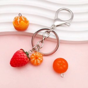 Bohemian acrylic fruit keychain featuring a red strawberry and orange charms on silver ring