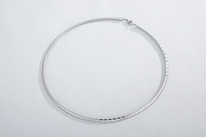 Detailed close-up of a silver stainless steel flat snake chain necklace with lobster clasp