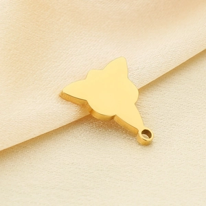 Gros plan d'un pendentif plat en métal doré sur fond de tissu texturé beige élégant