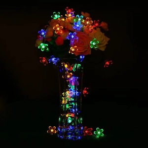 Macro detail of colorful LED cherry blossom lights glowing in a clear glass vase