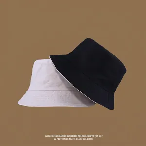 Detail showing stacked black and beige cotton sun hats with wide brims for UV protection