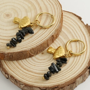 18k gold mushroom earrings with black natural stone beads on a wooden display