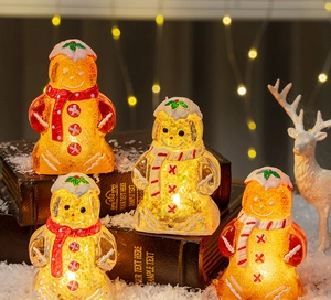 Detail of LED glowing gingerbread man ornaments with sparkling sequins and winter scarves