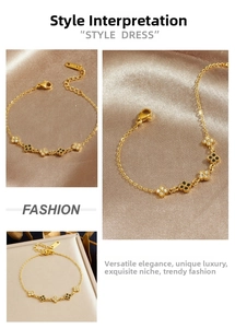 Detailed close-up of gold chain bracelet featuring black clover and white diamond charms