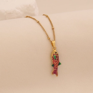 Detailed close-up of colorful enamel fish pendant with golden bead chain on textured stone