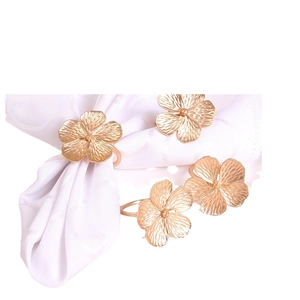 Set of four matte gold five-petal flower napkin rings for elegant wedding table decor