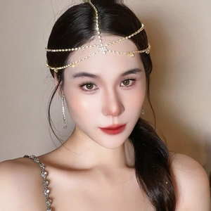 Détail de la chaîne de tête dorée multicouche et boucles d'oreilles sur un mannequin