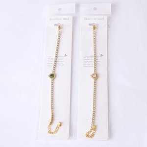 Detailed view of gold stainless steel bracelets with green and white heart zircon stones