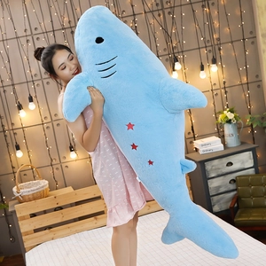 Extra large blue shark plush toy shell featuring red star embroidery held by a model
