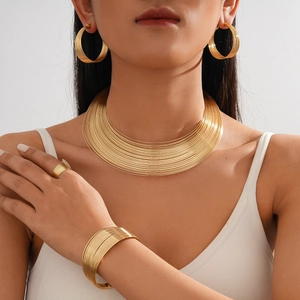 Detailed view of 4-piece gold multilayer geometric necklace set on model neck