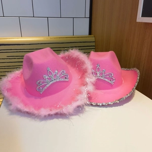 Detail view of pink western cowboy hats featuring feather trim, rhinestones and silver crowns