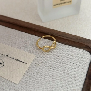 Macro shot of gold infinity symbol ring with bead design and adjustable open band