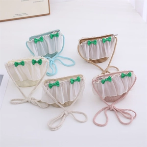 Detail of five assorted straw woven crossbody bags with lace trim and bow accents