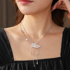 Close-up of double layer silver necklace with fan-shaped shell pendants and pearls