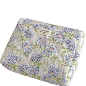 Quilted blue floral cosmetic bag with large capacity and portable handle for travel storage