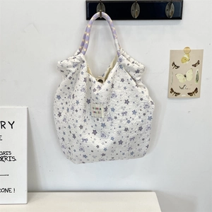 Detailed close-up of quilted canvas tote with bear prints and purple braided handles