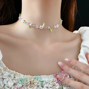 Detail of floral beaded choker necklace with pink and green resin flower patterns