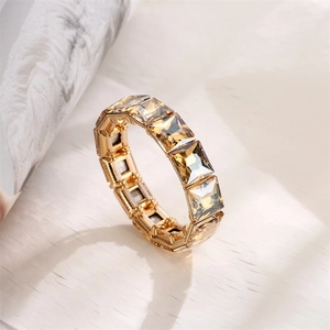 Macro shot of geometric champagne square crystals on a gold elastic stretch bracelet