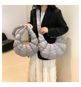 Detail of grey pleated dumpling bag showing soft quilted texture and crossbody strap