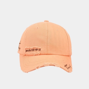 Detail of distressed apricot cotton baseball cap with vintage patches and side embroidery