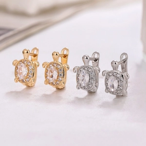 Close-up of gold and silver turtle stud earrings with sparkling cubic zirconia inlay