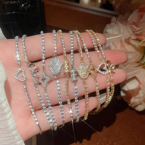 Close-up of tennis bracelets with zircon hearts and bows in gold and silver finishes
