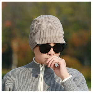 Detailed knit texture and decorative logo patch on beige winter beanie for men