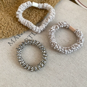 Detailed shot of three elastic hair ties in leopard print and woven knit textures
