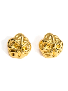 Macro detail of golden stainless steel earrings with unique irregular embossed texture