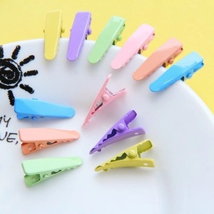 Close-up of colorful 4.8cm macaron duckbill hair clips on a white patterned plate