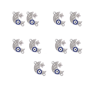Flat lay of silver moon and star charms with blue evil eye enamel and rhinestones