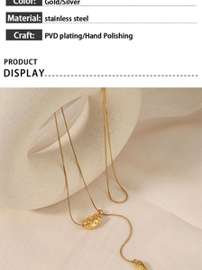 Detail of gold irregular geometric pendant on textured ceramic with PVD plating info