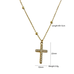 Détail du collier croix dorée avec pavé de zircons blancs et détails de chaîne perle